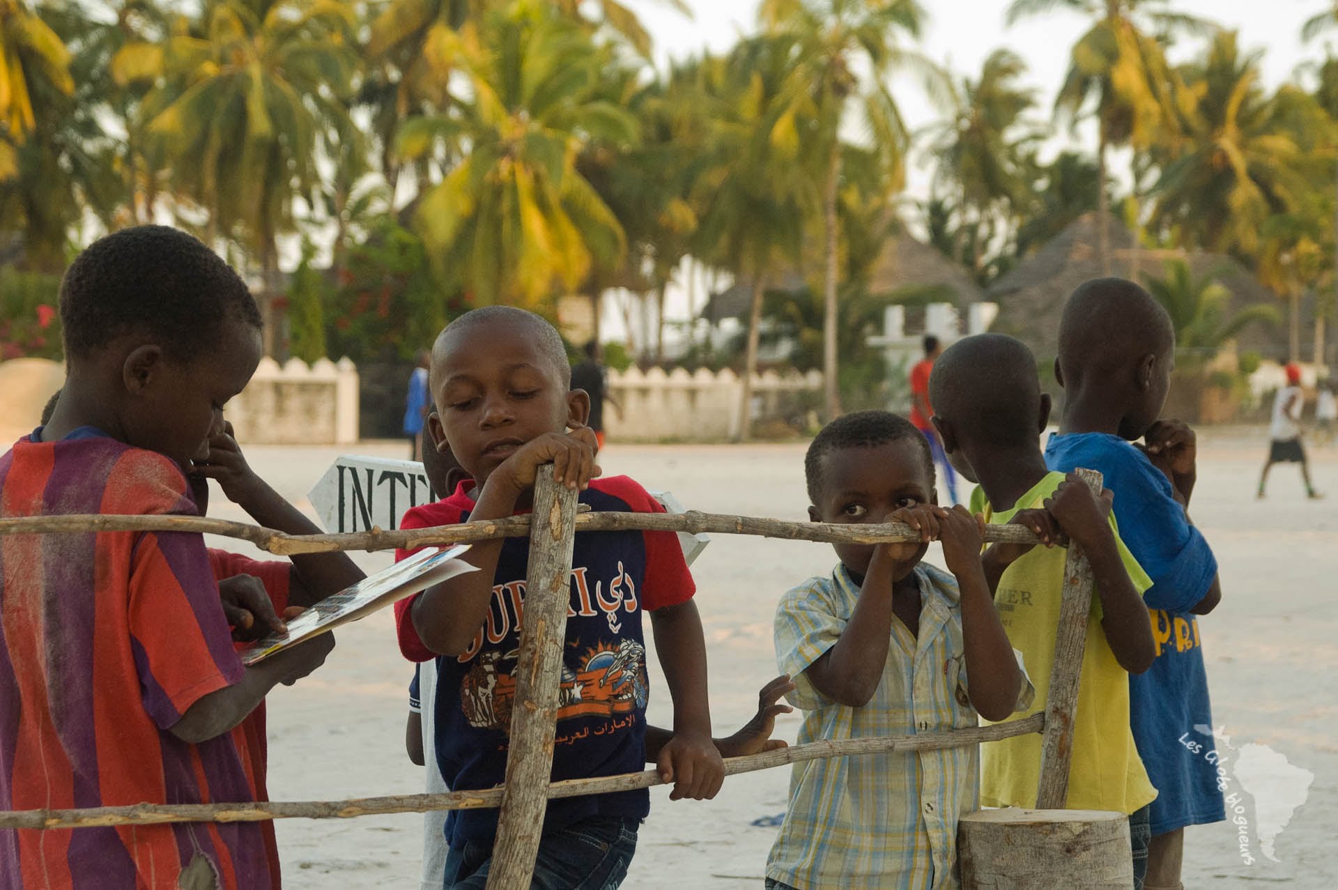Des enfants sur la plage du village de jambiani à Zanzibar, un dvd de bruce lee à la main